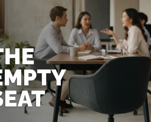 Marketing Got Outsourced. The Person Protecting Your Brand Went With It. 1 An empty chair at a small business meeting table, with colleagues seated around it out of focus — representing the vacant role of protecting a brand